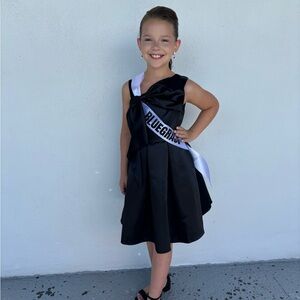 Black cocktail length girls dress.